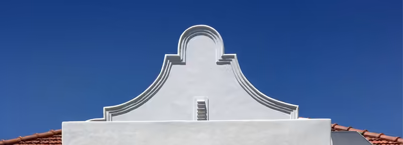 Restored Cape Dutch gable against a blue sky