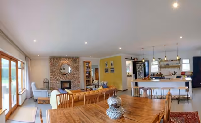Open-plan living, dining and kitchen with face-brick fireplace